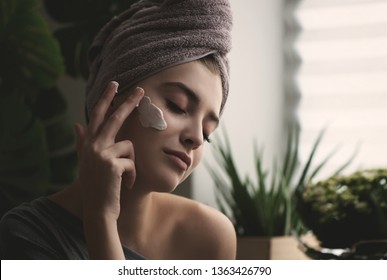 Woman applying skin care cream