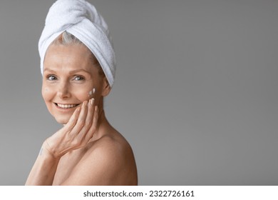 Mature woman applying skin care in wellness setting